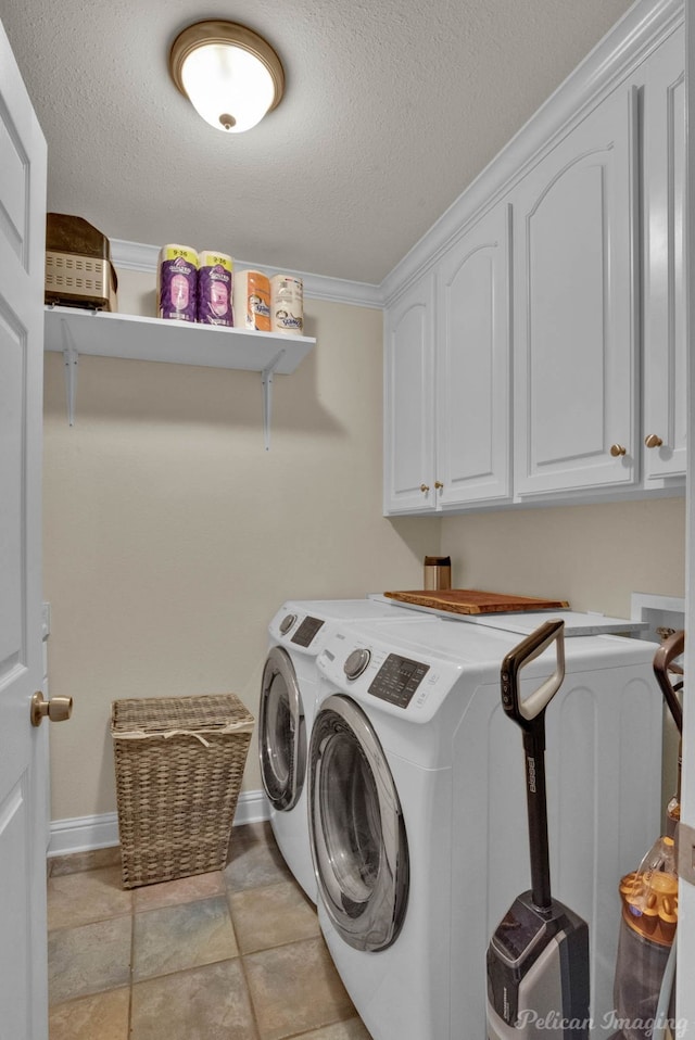 laundry area featuring washer and dryer, cabinets, a textured ceiling, and crown molding