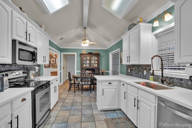 kitchen with white cabinets, lofted ceiling with beams, and stainless steel appliances