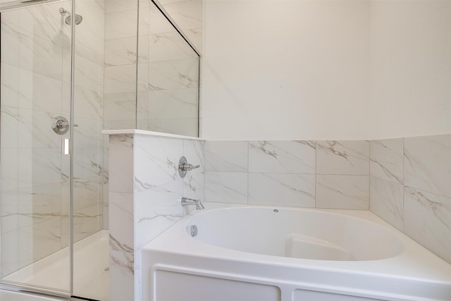 bathroom featuring shower with separate bathtub