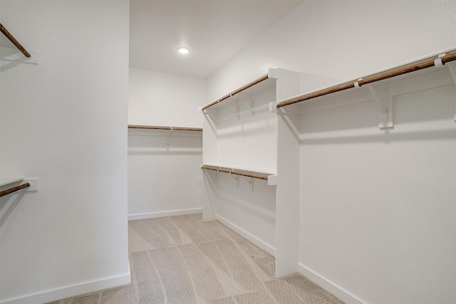 walk in closet featuring light carpet