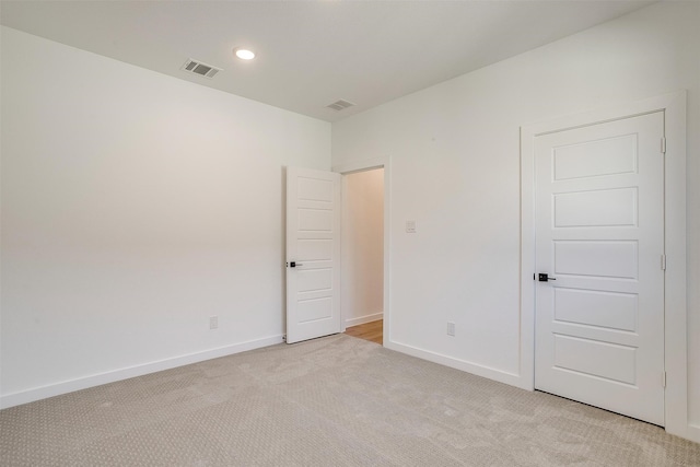 spare room featuring light colored carpet