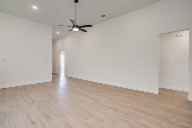 spare room featuring light hardwood / wood-style flooring, a high ceiling, and ceiling fan