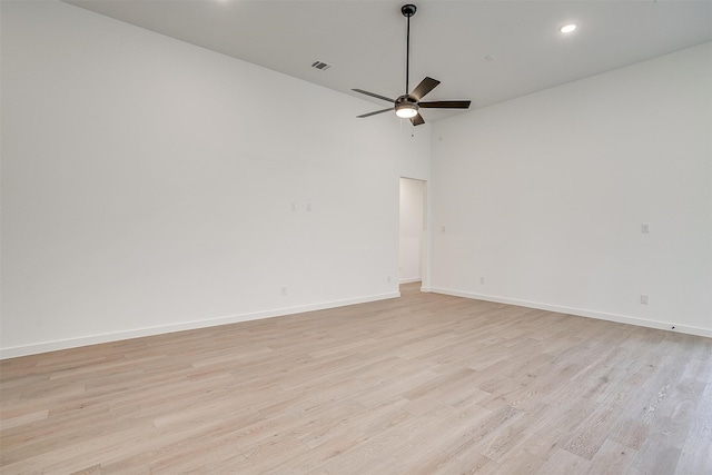 unfurnished room with a high ceiling, light hardwood / wood-style flooring, and ceiling fan