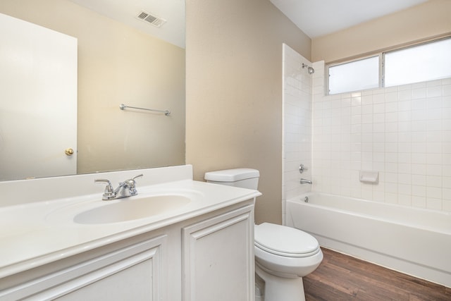 full bathroom with toilet, tiled shower / bath, vanity, and wood-type flooring