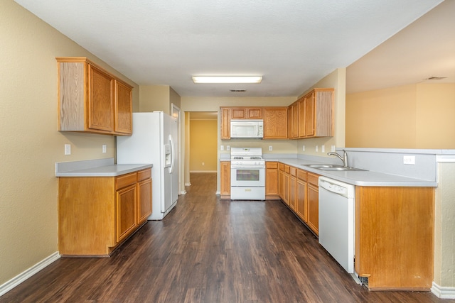 kitchen with white appliances, sink, kitchen peninsula, and dark hardwood / wood-style floors