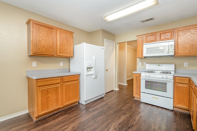 kitchen featuring white appliances and dark hardwood / wood-style flooring