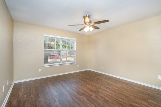 unfurnished room featuring dark wood-type flooring and ceiling fan