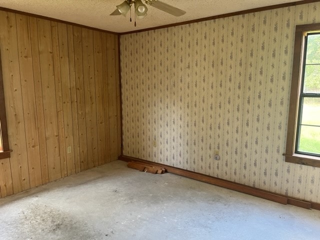 unfurnished room featuring ceiling fan, a healthy amount of sunlight, and a textured ceiling