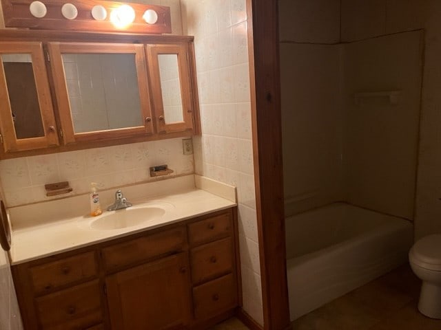 full bathroom with toilet, shower / bath combination, tile walls, vanity, and decorative backsplash