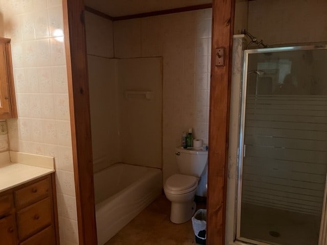 full bathroom with toilet, tile patterned flooring, separate shower and tub, tile walls, and vanity