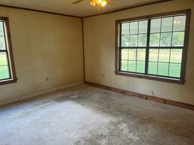 unfurnished room with ceiling fan, crown molding, a textured ceiling, and concrete flooring