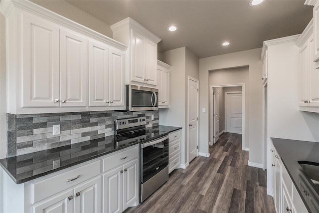 kitchen featuring appliances with stainless steel finishes, decorative backsplash, white cabinetry, and dark hardwood / wood-style floors