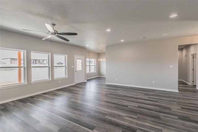 unfurnished living room featuring a textured ceiling, dark hardwood / wood-style flooring, and ceiling fan with notable chandelier