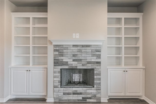 unfurnished living room with dark wood-type flooring and a fireplace