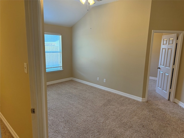 empty room featuring light carpet, vaulted ceiling, and ceiling fan