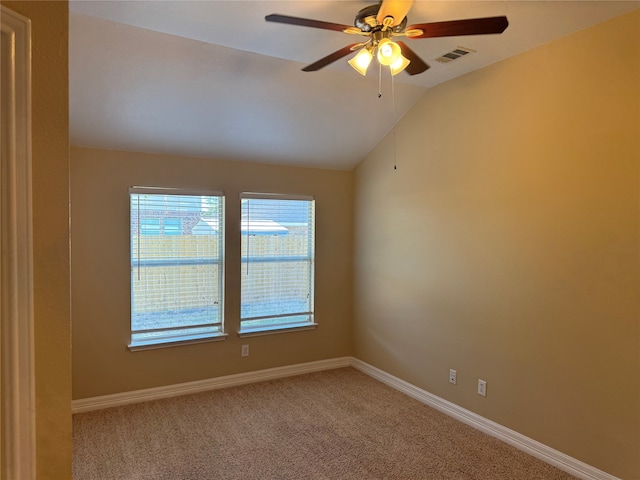 spare room with ceiling fan, vaulted ceiling, and carpet floors