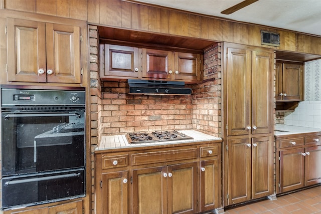 kitchen with decorative backsplash, stainless steel gas stovetop, and oven