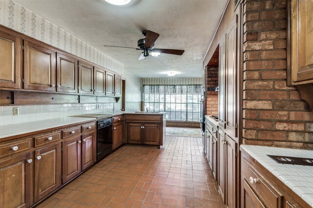 kitchen featuring tile countertops, black dishwasher, tasteful backsplash, a textured ceiling, and ceiling fan