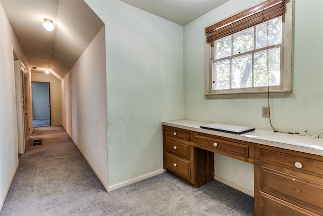 office space with built in desk and light carpet