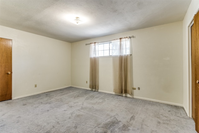 carpeted spare room featuring a textured ceiling