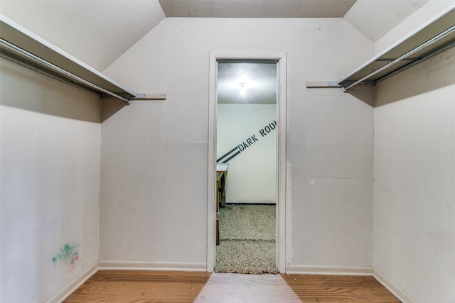 walk in closet featuring hardwood / wood-style floors and vaulted ceiling