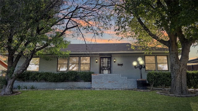 single story home with a lawn