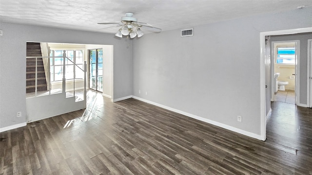 interior space featuring a textured ceiling, ceiling fan, dark wood-type flooring, and a wealth of natural light