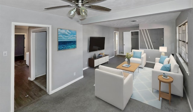 living room with beamed ceiling, dark wood-type flooring, and ceiling fan