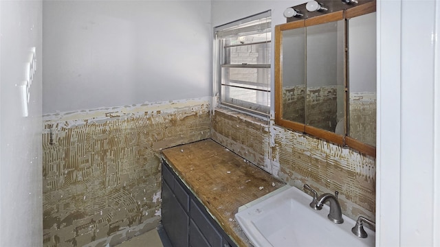 bathroom featuring vanity and tile walls