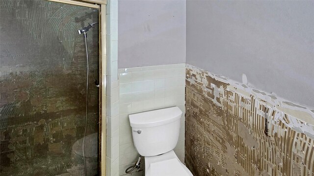 5706 Rocky Ridge Rd, Dallas, TX 75241 - full bathroom featuring toilet, tile walls, a shower stall, and a wainscoted wall