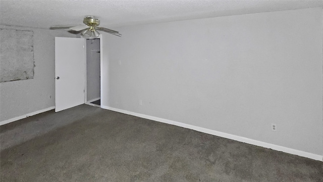 empty room with ceiling fan, a textured ceiling, and dark carpet