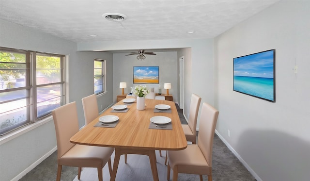 dining room with dark colored carpet and ceiling fan