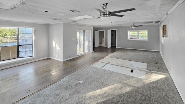 empty room with a textured ceiling, ceiling fan, and dark hardwood / wood-style flooring