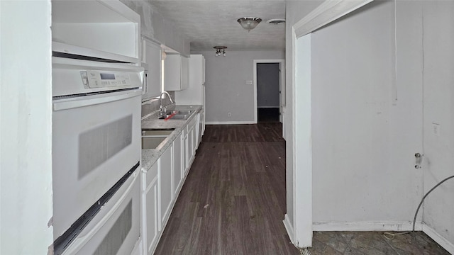 5706 Rocky Ridge Rd, Dallas, TX 75241 - kitchen featuring double oven, a sink, white cabinetry, baseboards, and light countertops