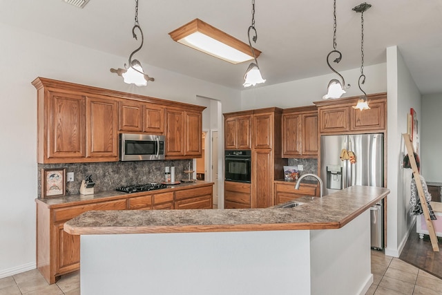 kitchen featuring black appliances, pendant lighting, sink, and a kitchen island with sink