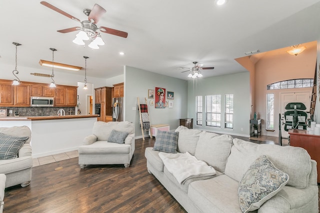 living room with ceiling fan and dark wood-type flooring