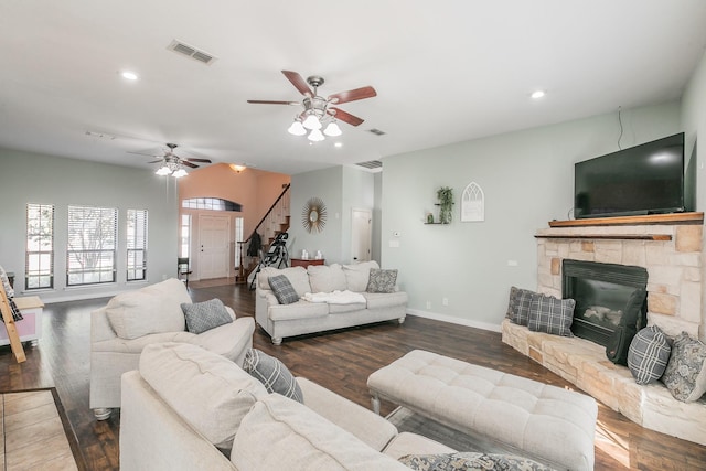 living room with dark hardwood / wood-style flooring, ceiling fan, and a fireplace