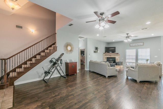 living room with a fireplace, dark hardwood / wood-style flooring, and ceiling fan