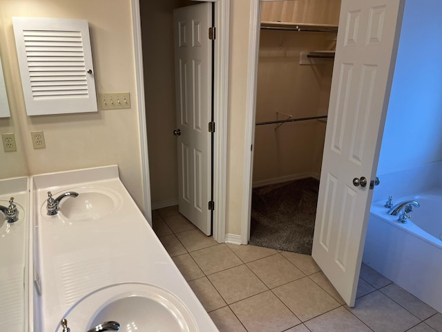 bathroom with tile patterned floors, vanity, and a tub