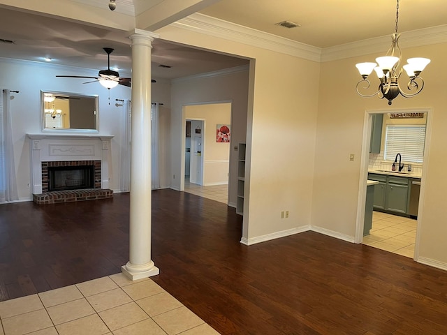 unfurnished living room featuring a brick fireplace, light hardwood / wood-style flooring, crown molding, and sink