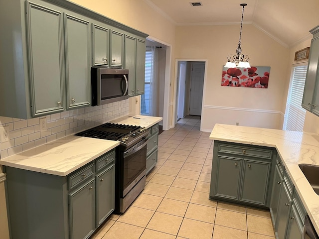 kitchen with vaulted ceiling, appliances with stainless steel finishes, tasteful backsplash, hanging light fixtures, and crown molding