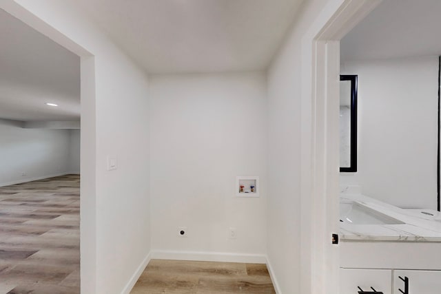 washroom with hookup for a washing machine, light wood-type flooring, and electric dryer hookup