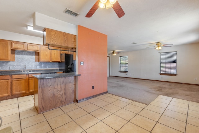 kitchen with tasteful backsplash, ceiling fan, light tile patterned floors, black fridge with ice dispenser, and sink