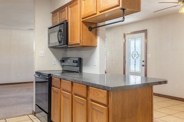 kitchen featuring black appliances, light tile patterned floors, and kitchen peninsula