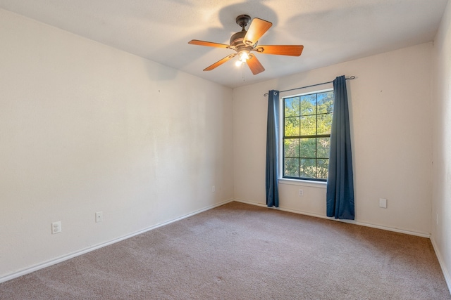 carpeted spare room featuring ceiling fan