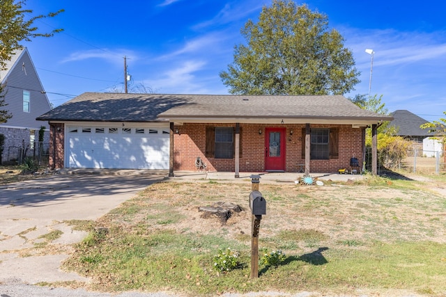 ranch-style house featuring covered porch, a front yard, and a garage