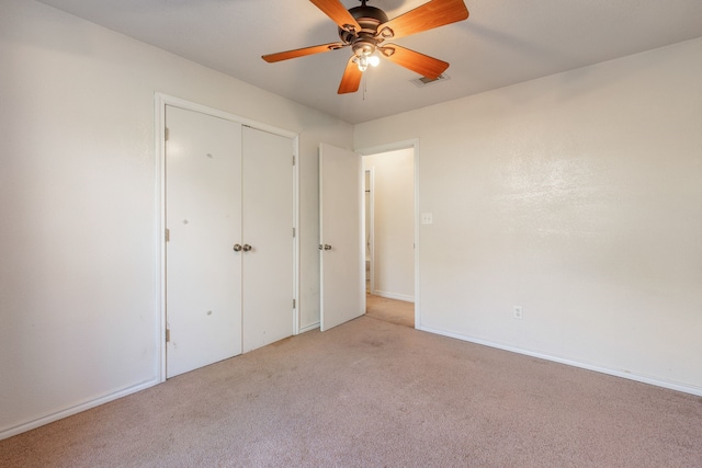 unfurnished bedroom featuring a closet, ceiling fan, and light colored carpet