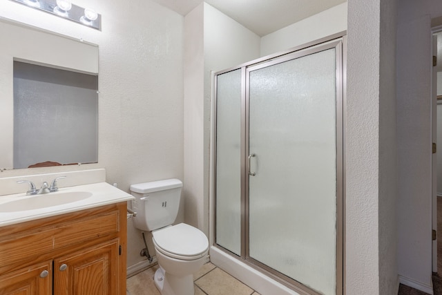 bathroom featuring vanity, toilet, walk in shower, and tile patterned flooring