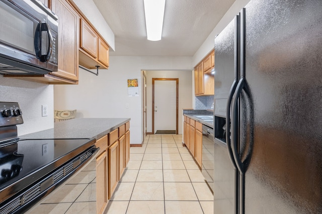 kitchen featuring black appliances, light brown cabinetry, and light tile patterned floors