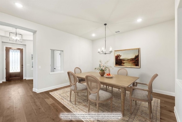 dining space featuring dark hardwood / wood-style floors and a notable chandelier